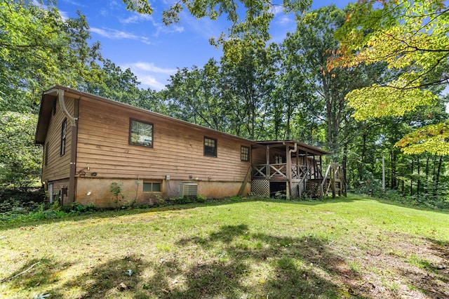 rear view of property featuring cooling unit and a lawn