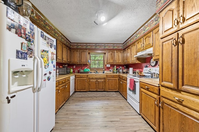 kitchen featuring crown molding, light hardwood / wood-style flooring, white appliances, sink, and a textured ceiling