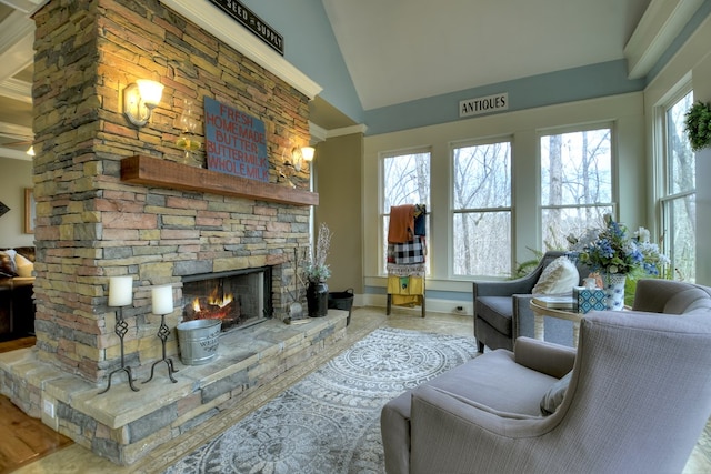 living room with a stone fireplace, a wealth of natural light, and high vaulted ceiling