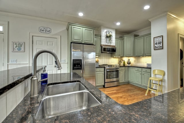 kitchen featuring green cabinets, appliances with stainless steel finishes, sink, and ornamental molding