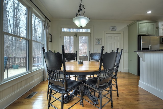 dining room with ornamental molding and light wood-type flooring