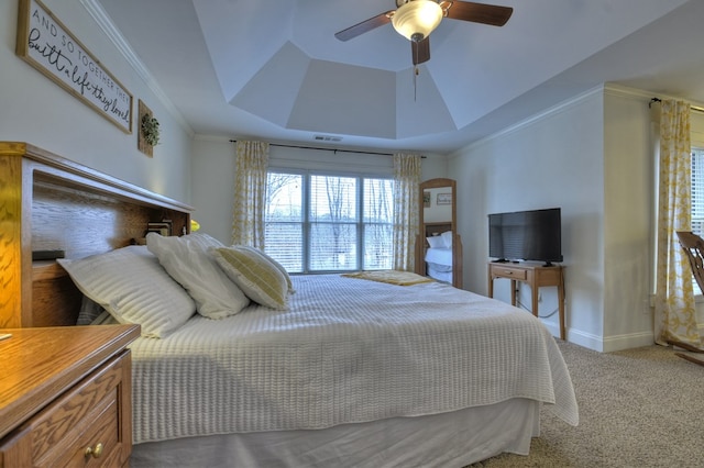 bedroom featuring ceiling fan, a tray ceiling, and carpet