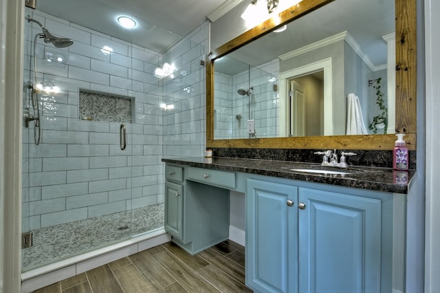 bathroom with crown molding, vanity, and walk in shower