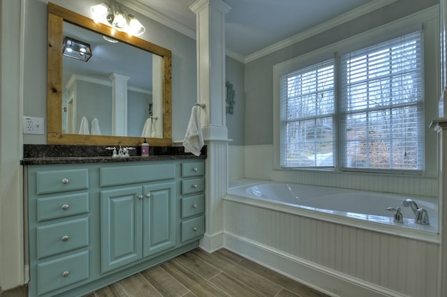 bathroom featuring vanity, crown molding, a bathing tub, and ornate columns