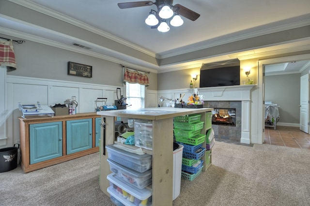 kitchen featuring crown molding, light colored carpet, a multi sided fireplace, and ceiling fan