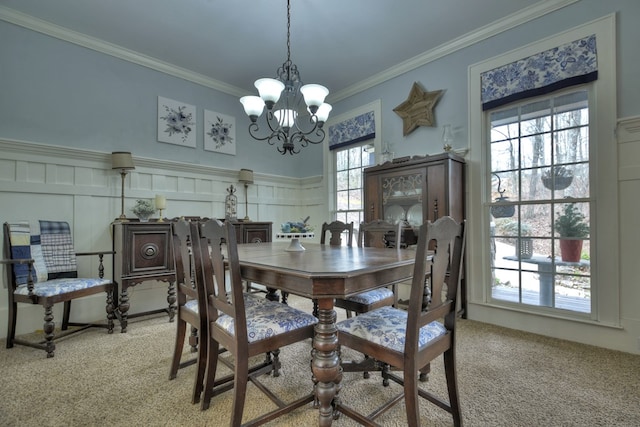 carpeted dining room featuring an inviting chandelier, crown molding, and plenty of natural light