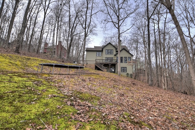 view of yard featuring a trampoline and a wooden deck