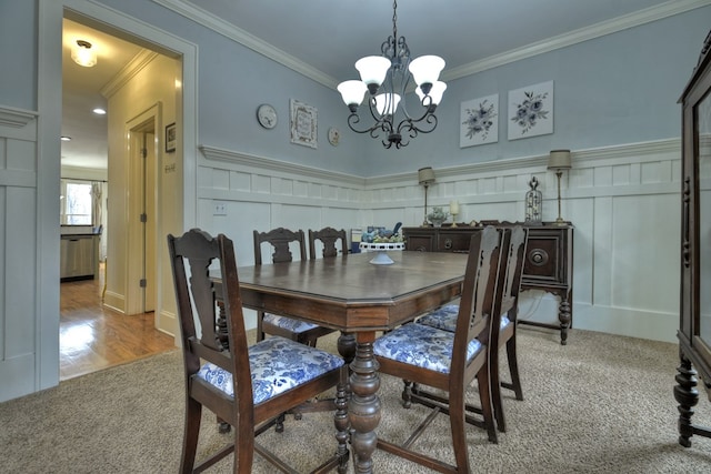 dining room with crown molding, an inviting chandelier, and light hardwood / wood-style flooring