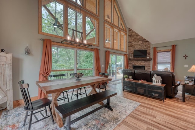 784 Sneaking Creek Dr, Hayesville, NC 28904 - dining room featuring high vaulted ceiling, a ceiling fan, light wood finished floors, and a stone fireplace