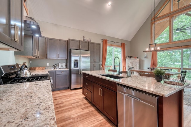 784 Sneaking Creek Dr, Hayesville, NC 28904 - kitchen with appliances with stainless steel finishes, high vaulted ceiling, light wood-style flooring, ventilation hood, and light stone counters