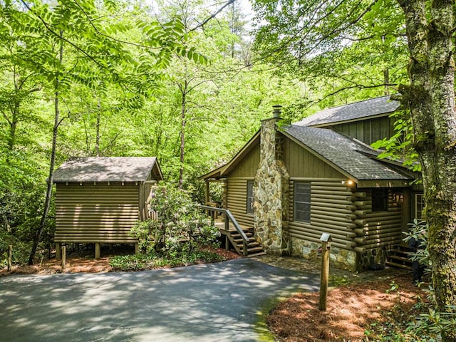 240 Donna Lee Ln, Mineral Bluff, GA 30559 - view of side of property with a chimney, log siding, a shingled roof, and a wooded view