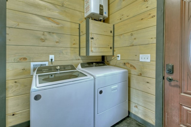 washroom with washing machine and dryer and wood walls