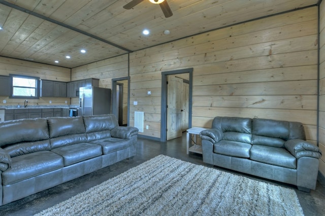 living room featuring wood ceiling, ceiling fan, wooden walls, and sink