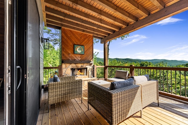 deck with a mountain view and an outdoor living space with a fireplace