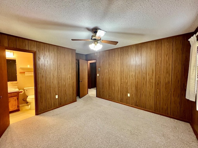 136 Ashe Knob Dr, Hayesville, NC 28904 - unfurnished bedroom featuring carpet floors, wood walls, ensuite bath, ceiling fan, and a textured ceiling