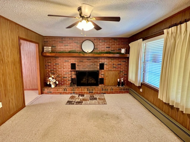 unfurnished living room with a baseboard radiator, ceiling fan, a textured ceiling, carpet floors, and wooden walls