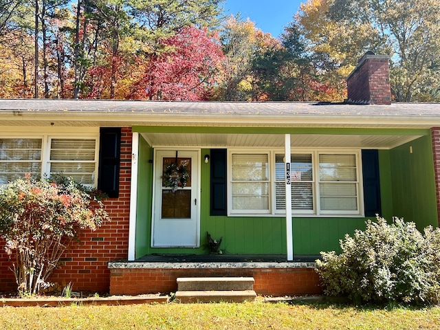 136 Ashe Knob Dr, Hayesville, NC 28904 - doorway to property featuring a chimney, a porch, and brick siding