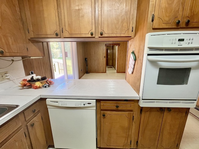 136 Ashe Knob Dr, Hayesville, NC 28904 - kitchen featuring white appliances, a peninsula, light countertops, and brown cabinets