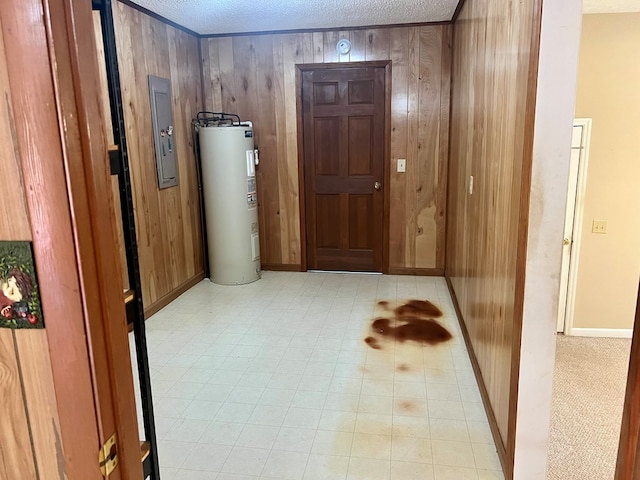 hall featuring wood walls, electric water heater, electric panel, and a textured ceiling