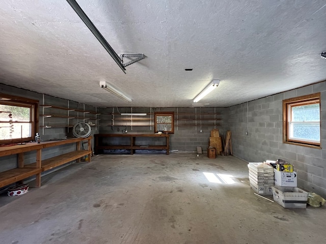 basement with a textured ceiling, a workshop area, and plenty of natural light