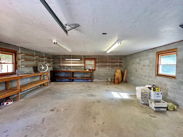 basement with a healthy amount of sunlight, a workshop area, and a textured ceiling