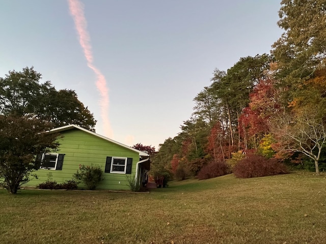 property exterior at dusk featuring a yard