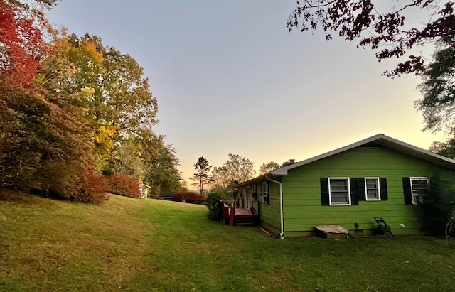 property exterior at dusk with a lawn