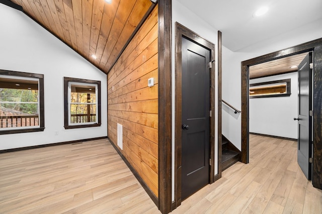 hallway featuring lofted ceiling, wood ceiling, and light wood-type flooring