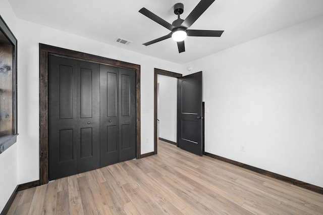 unfurnished bedroom featuring a closet, light hardwood / wood-style floors, and ceiling fan