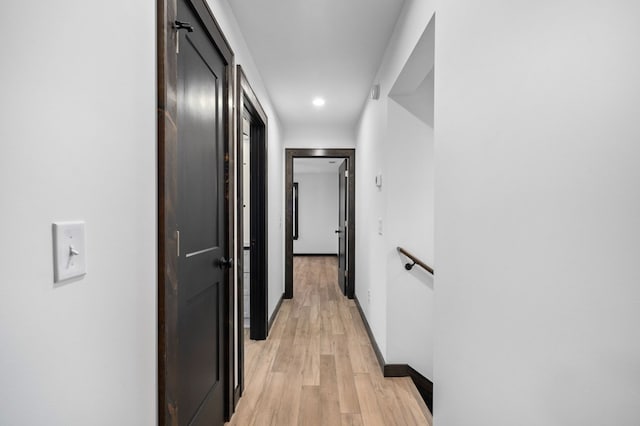 hallway with light hardwood / wood-style floors