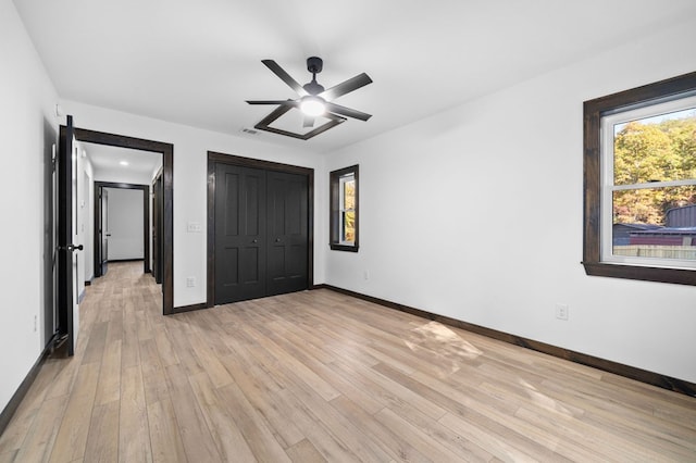 unfurnished bedroom with light hardwood / wood-style flooring, a closet, and ceiling fan