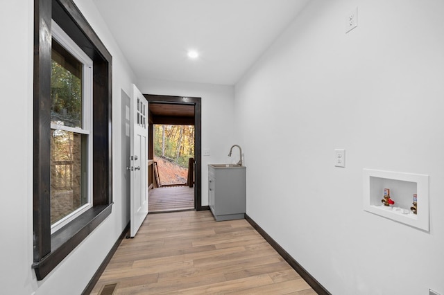 interior space with sink, light hardwood / wood-style flooring, and plenty of natural light