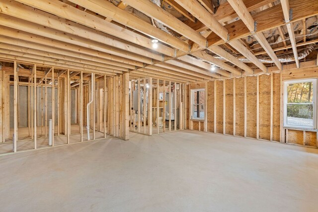 miscellaneous room featuring concrete floors, water heater, and electric panel