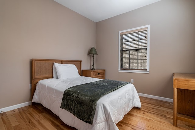 bedroom with baseboards and wood finished floors