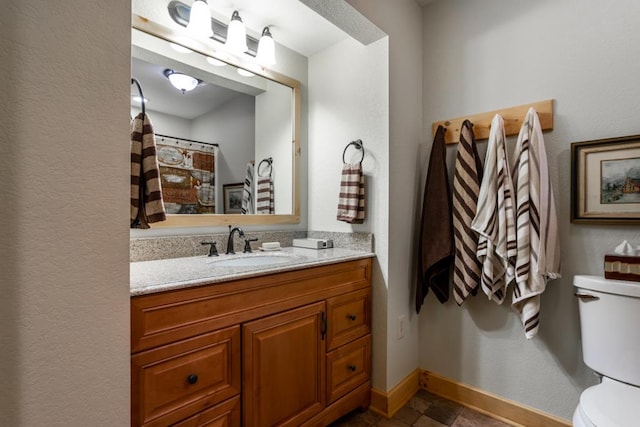 bathroom featuring vanity, toilet, and baseboards