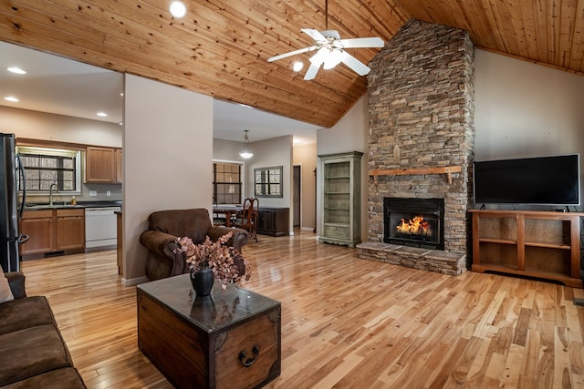 living room featuring light wood-type flooring, high vaulted ceiling, wooden ceiling, and a fireplace