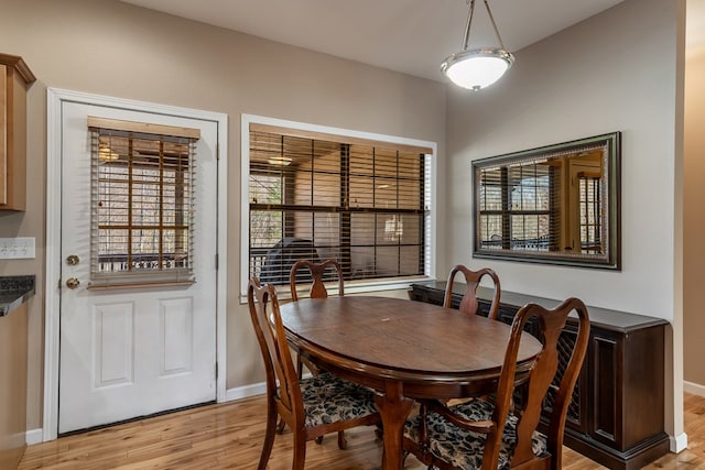 dining space with light wood-style flooring and baseboards