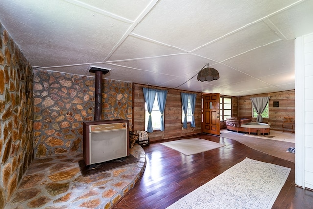 unfurnished living room featuring french doors, a textured ceiling, dark hardwood / wood-style floors, and wooden walls