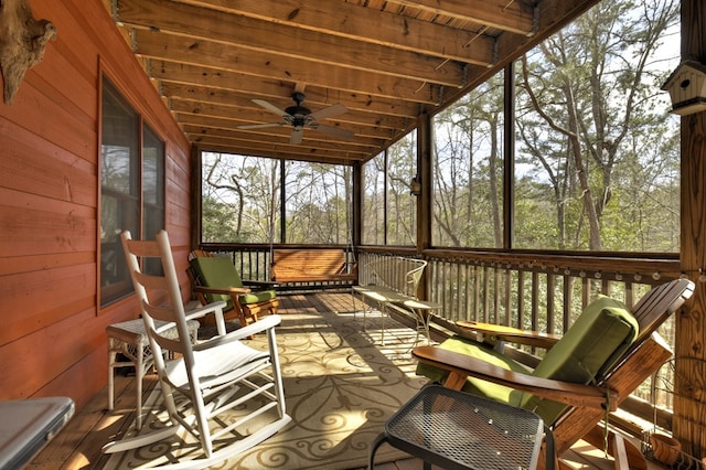 sunroom / solarium with wood ceiling and a ceiling fan