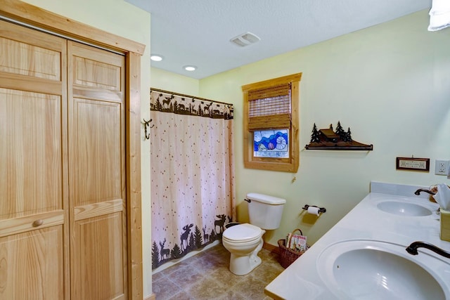 bathroom with a shower with curtain, double vanity, toilet, and a sink