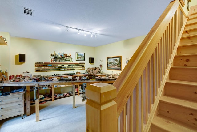 playroom with visible vents, light carpet, a workshop area, and a textured ceiling