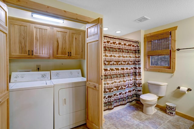 washroom with visible vents, a textured ceiling, cabinet space, baseboards, and washing machine and clothes dryer