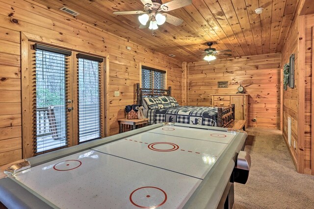 recreation room featuring carpet flooring, ceiling fan, wood walls, and wood ceiling