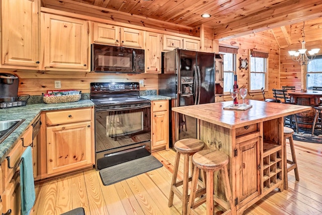 kitchen featuring wooden ceiling, an inviting chandelier, wood walls, black appliances, and light wood-type flooring