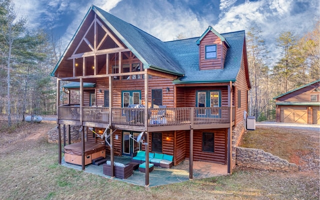 rear view of property with a wooden deck and a patio