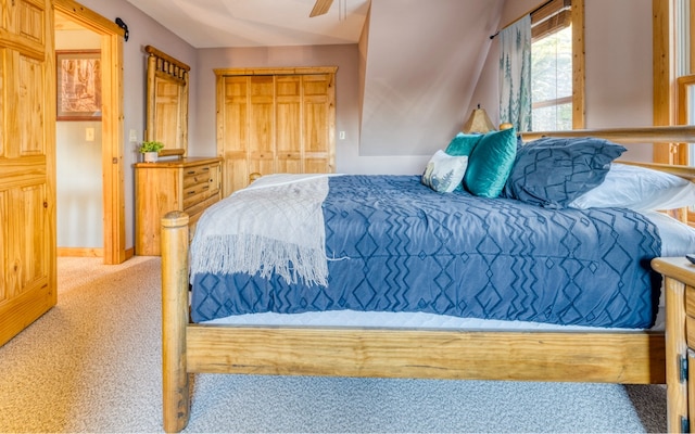 bedroom with a closet, light carpet, and ceiling fan