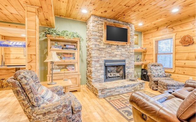 living room with wooden walls, rustic walls, a stone fireplace, wood ceiling, and light hardwood / wood-style flooring