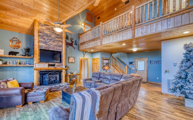 living room with high vaulted ceiling, a fireplace, ceiling fan, wood ceiling, and light hardwood / wood-style flooring