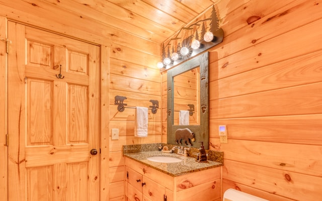 bathroom with wooden walls, toilet, oversized vanity, and wooden ceiling