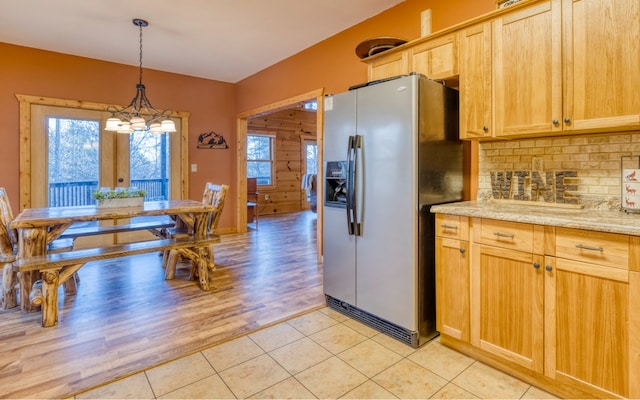 kitchen with backsplash, a notable chandelier, light hardwood / wood-style flooring, stainless steel fridge with ice dispenser, and hanging light fixtures